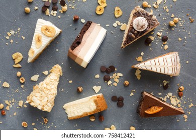 Assortment of pieces of cake on messy table, copy space. Several slices of delicious desserts, restaurant menu concept, top view