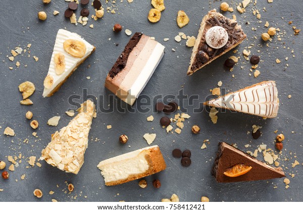 Assortment of pieces of cake on messy table, copy\
space. Several slices of delicious desserts, restaurant menu\
concept, top view