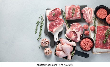 Assortment of raw meats on grey background. Top view with copy space