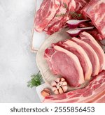 Assortment of raw pork meat on light grey background. Organic gourmet food concept. Top view, flat lay, copy space