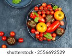 Assortment of ripe tomatoes varieties. Platter of colorful tomatoes and cherry tomatoes.