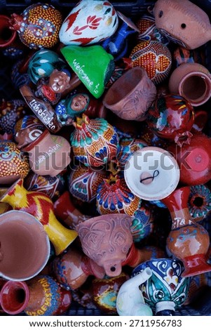 An assortment of rustic ceramic dishes and bells are on sale at a local market in Tashkent, Uzbekistan. High quality photo
