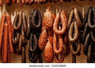 Assortment of smoked sausage and salami hanging in a supermarket. Delicacy and butchery shop - Powered by Shutterstock