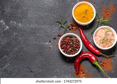 Assortment of spices, and herbs on black rustic background with copy space for your design top view.