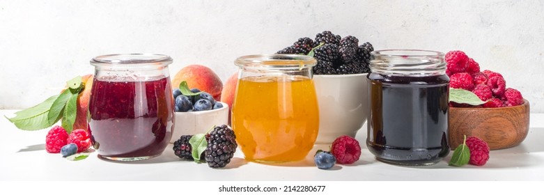 Assortment of summer seasonal berry and fruits jams in small jars, homemade preserving concept, marmalades or confitures with fresh berries on white background copy space - Shutterstock ID 2142280677
