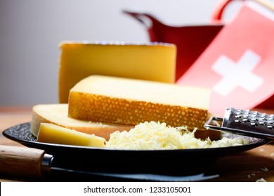 Assortment Of Swiss Cheeses Emmental Or Emmentaler Medium-hard Cheese With Round Holes, Gruyere, Appenzeller And Raclette Used For Traditional Cheese Fondue And Gratin And Flag Of Switzerland