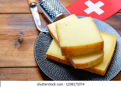 Assortment Of Swiss Cheeses Emmental Or Emmentaler Medium-hard Cheese With Round Holes, Gruyere, Appenzeller And Raclette Used For Traditional Cheese Fondue And Gratin And Flag Of Switzerland