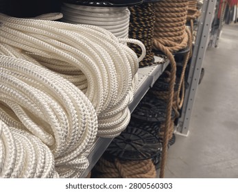 Assortment of thick structural ropes and heavy cordage on racks inside a DIY hardware store, hardware industrial equipment. High quality photo
