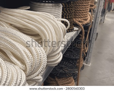 Assortment of thick structural ropes and heavy cordage on racks inside a DIY hardware store, hardware industrial equipment. High quality photo
