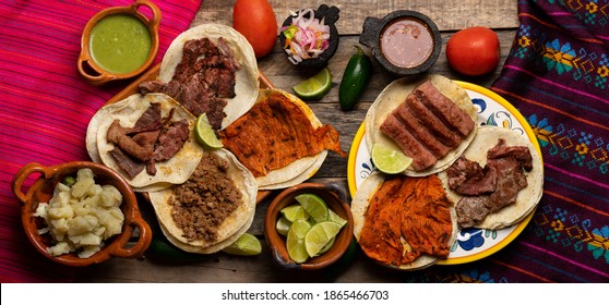 Assortment of traditional mexican tacos on wooden background