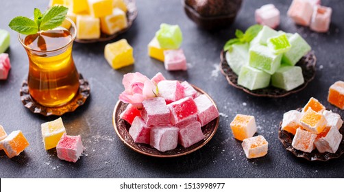 Assortment of Turkish delights with glass of tea. Grey background. - Shutterstock ID 1513998977
