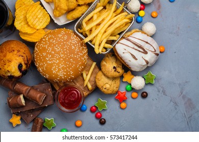 Assortment of unhealthy products that's bad for figure, skin, heart and teeth. Fast carbohydrates food. Space for text - Shutterstock ID 573417244