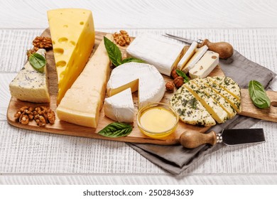 An assortment of various cheeses arranged on a board, highlighting different textures, colours, and types, perfect for a tasting or appetizer - Powered by Shutterstock