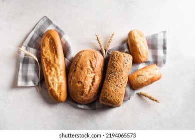 Assortment of various delicious freshly baked bread on white background. Variety of artisan bread composition and ears of wheat. - Powered by Shutterstock