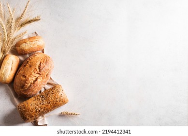 Assortment of various delicious freshly baked bread on white background, copy space. Variety of artisan bread composition and ears of wheat. - Powered by Shutterstock