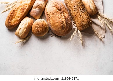 Assortment of various delicious freshly baked bread on white background, copy space. Variety of artisan bread composition and ears of wheat. - Powered by Shutterstock