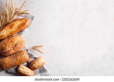 Assortment of various delicious freshly baked bread on white background. Variety of artisan bread composition and ears of wheat. - Powered by Shutterstock