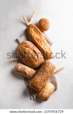 Assortment of various delicious freshly baked bread. Variety of artisan bread and ears of wheat.