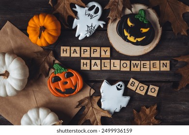 Assortment of various homemade gingerbread cookies and Happy Halloween Boo message in wooden blocks on dark background. Handmade scary treat and simple decor for a kid's home holiday party. Flat lay - Powered by Shutterstock