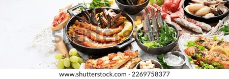 Assortment various Mediterranean food - fish, octopus, shrimp,  seafood, mussels, sauces, pasta, pizza on a white background. Top view. Panorama with copy space.