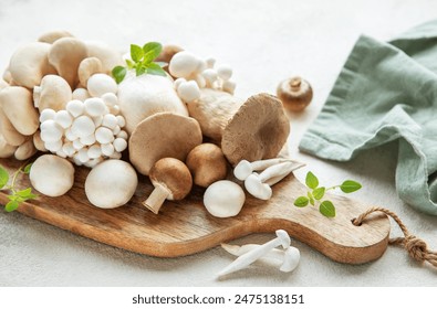 Assortment of various raw mushrooms on gray concrete background - Powered by Shutterstock