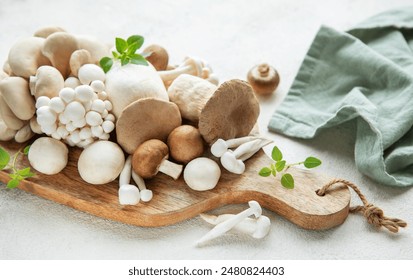 Assortment of various raw mushrooms on gray concrete background - Powered by Shutterstock