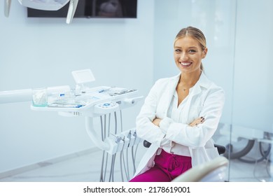 Assure And Beautiful Dental Doctor With Brilliant Healthy Smile All Over Her Face In Front Of Dentist Room. Dental Professional. Portrait Of Female Dentist .She Standing In Her Dentist Office..