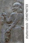 Assyrian Court Servant Probably a Eunuch holding tributary lion shaped buckets from king Sargon II capital city of Dur Sharrukin Khorsabad In Nineveh Iraq, On display at the Louvre Museum in Paris