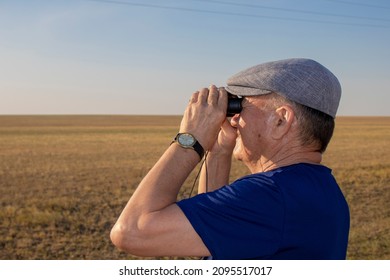 Astana Kazakstan Dec 24 2021: Old Man In The Steppet Looking Through Binoculars