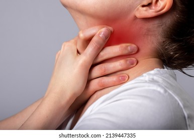 Asthma attack. Woman suffocating, breathing heavily. Sore throat. Hands holding neck with red spot closeup. Respiratory diseases, medicine concept. High quality photo