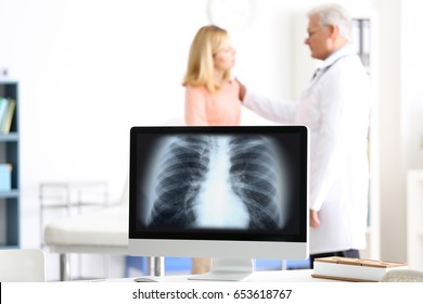 Asthma And Health Care Concept. Computer With Chest X-ray Scan On Screen. Doctor And  Patient On Background