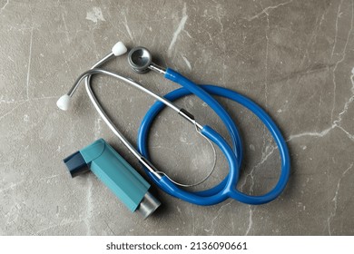 Asthma Inhaler And Stethoscope On Gray Textured Table