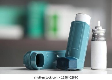 Asthma inhalers on table against blurred background. Space for text