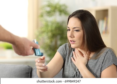 Asthmatic Girl Suffering An Asthma Attack Receiving An Inhaler At Home