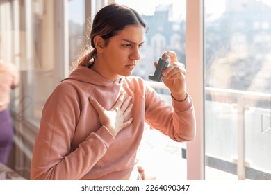 An asthmatic girl who takes an inhaler and has an asthma attack. She has a problem with asthma and holding an inhaler.