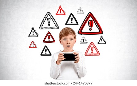 Astonished boy with smartphone standing near concrete wall with cybersecurity warning signs. Concept of cyberscurity and parental control - Powered by Shutterstock