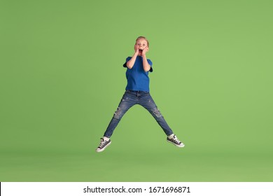 Astonished. Happy Boy Playing And Having Fun On Green Studio Background. Caucasian Kid In Bright Cloth Looks Playful, Laughting, Smiling. Concept Of Education, Childhood, Emotions, Facial Expression.