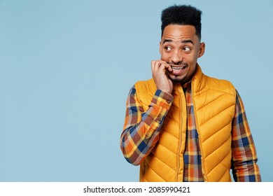 Astonished Impressed Shocked Curious Young Black Man 20s Years Old Wears Yellow Waistcoat Shirt Looking Away Gnaws Nervously Fingernails Isolated On Plain Pastel Light Blue Background Studio Portrait