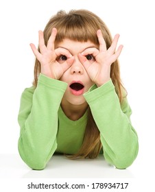 Astonished Little Girl Is Showing Glasses Gesture, Isolated Over White