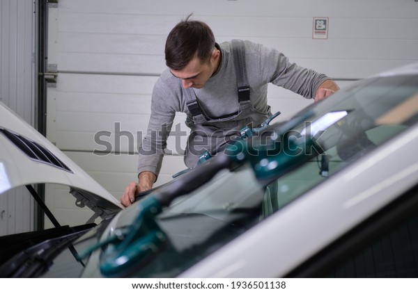 Astrakhan,\
Russia — 13.3.2021: a car service worker changes the windshield to\
a Mercedes ML, blurred objects, with a shallow depth of field,\
bokeh, and blurred background and\
foreground