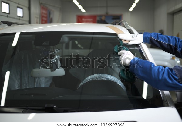 Astrakhan,\
Russia — 13.3.2021: a car service worker changes the windshield to\
a Mercedes ML, blurred objects, with a shallow depth of field,\
bokeh, and blurred background and\
foreground