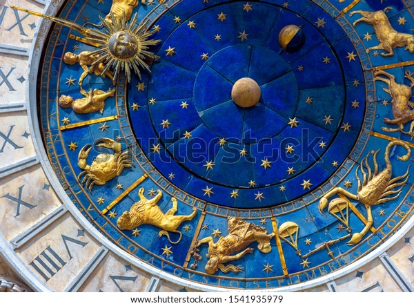 Астрологические знаки на старинных часах Torre dell'Orologio, Венеция, Италия. Средневековое колесо зодиака и созвездия. Золотые символы на звездном круге. Концепция астрологии, гороскопа и времени.