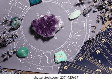 Astrology prediction. Zodiac wheel, gemstones, tarot cards and lavender on wooden table, flat lay