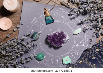 Astrology prediction. Zodiac wheel, gemstones, tarot cards and burning candles on wooden table, flat lay - Powered by Shutterstock