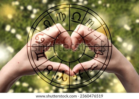 Astrology. Zodiac wheel and woman making heart with hands against bright background, closeup
