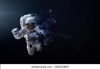 Astronaut breaks up into particles in space. Abstract wallaper. Destruction and disappearance. Elements of this image furnished by NASA