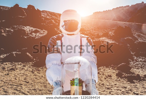 Astronaut bringing plant\
box in other planet - Spaceman trying to bring life into new galaxy\
- Saving the environment mission, discovering, and future concept -\
Focus on helmet