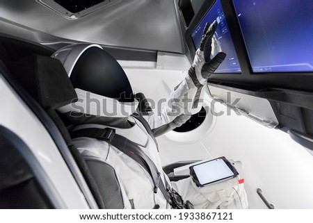Astronaut commanding a spaceship flying through outer space. Elements of this image furnished by NASA.