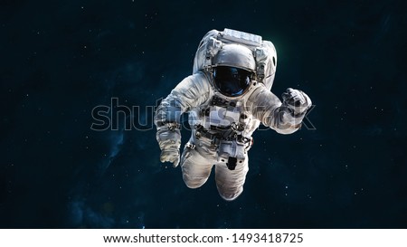 Astronaut in dark deep space. Science wallpaper. Elements of this image furnished by NASA