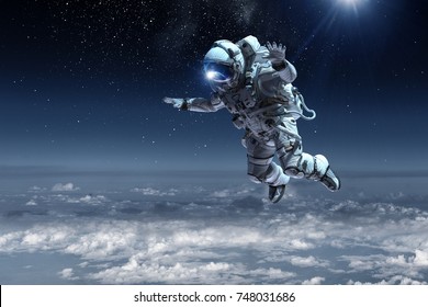 Astronaut floating above clouds